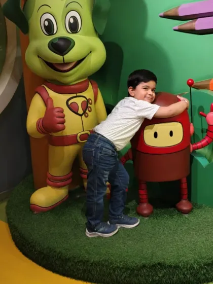 This little guy shares a hug with our robot mascot, Boxy, showing his affection.