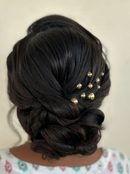 A close up of the detailed, woven bun with gold beads.