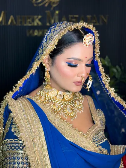 A side profile of the royal blue bridal look, focusing on the eye makeup and jewellery. The blue winged liner complements the outfit perfectly.