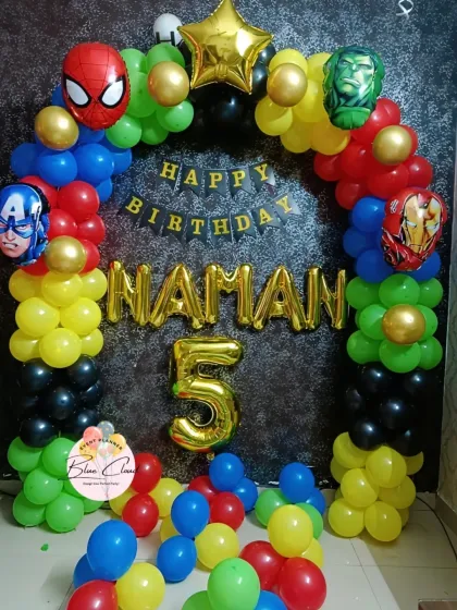 An Avengers-themed birthday party with a colorful balloon arch featuring Spiderman, Hulk, Captain America, and Iron Man foils.