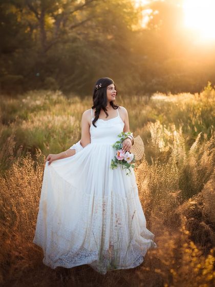 Holding a bouquet of flowers, the mom to be looks like she's stepped out of a fairytale. The warm sunlight and natural setting make this a truly enchanting maternity portrait.
