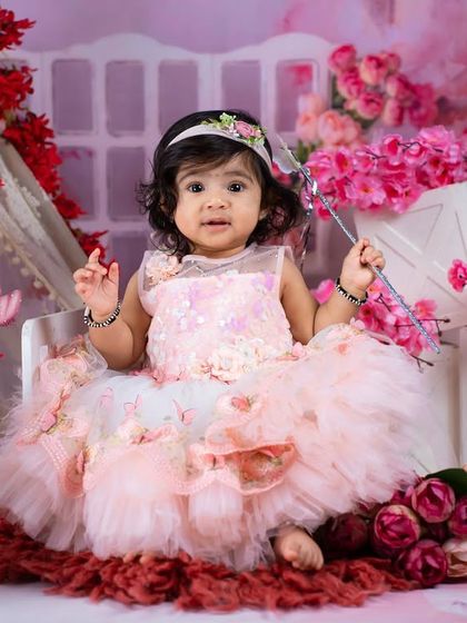 Our little fairy is ready to grant some wishes with her magic wand in this lovely pink and red floral setup.