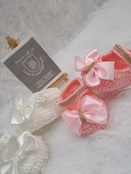 These elegant booties come in both white and pink, featuring a large satin bow with a sparkling, stone-studded center.