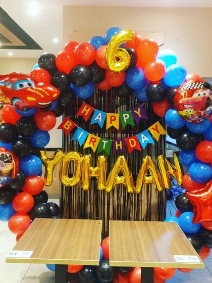 A clear shot of the racing cars balloon arch, showing the mix of red, blue, and black balloons with themed foil accents.
