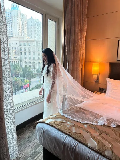 A beautiful shot of the bride looking out the window, her long veil cascading down, creating a dreamy and romantic image.