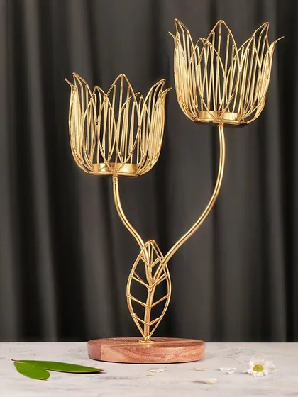 An elegant, styled shot of a golden tulip-shaped candle holder. For home decor photography, I create a mood that complements the product, using soft lighting and simple props to showcase its design and function.