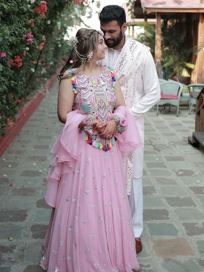 A picture-perfect couple at their Mehendi. Her makeup is soft and natural, letting her happiness and the vibrant colors of her outfit shine through.