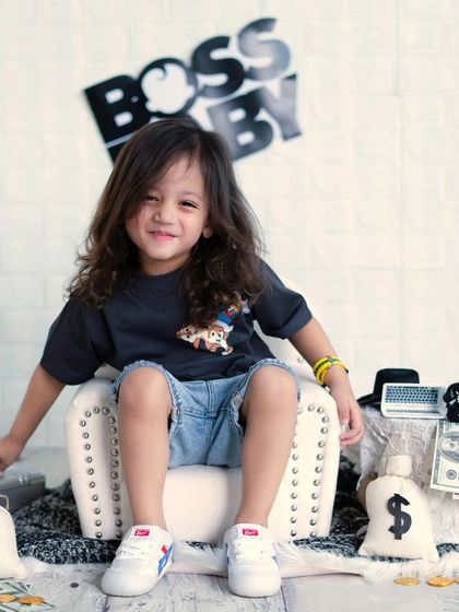 A future model in the making. This older boy is rocking the 'Boss Baby' theme with his cool pose and confident smile.