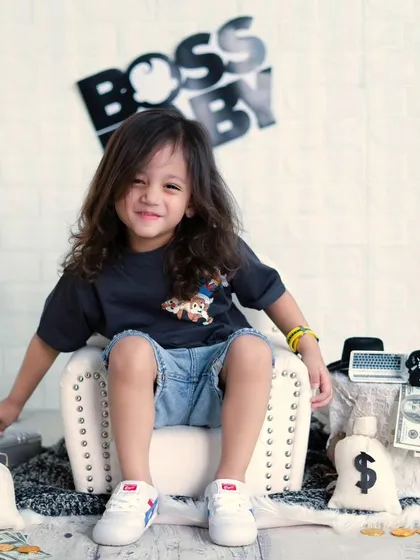 A future model in the making. This older boy is rocking the 'Boss Baby' theme with his cool pose and confident smile.
