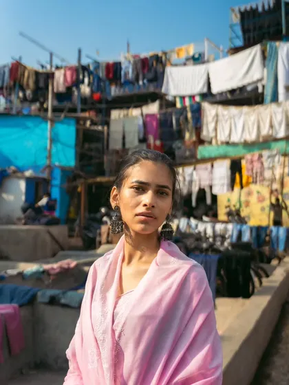 This wide shot captures the scale and organized chaos of Dhobi Ghat, with the model as a calm presence in the middle of it all.