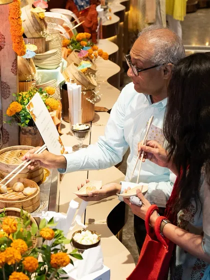 Guests interacting with our chef at a live dim sum counter. This image perfectly illustrates how our live stations become a focal point for engagement and enjoyment.