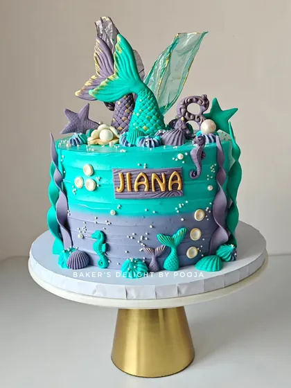 An underwater dream in shades of turquoise and purple. This mermaid theme cake for an eighth birthday is adorned with detailed mermaid tails, seahorses, and seashells for a magical ocean vibe.