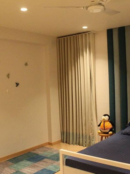 A playful yet stylish kid's bedroom from our Hyderabad project. The striped blue and green upholstered headboard adds a pop of color and texture, while the custom "AMARN" pillow personalizes the space. We aimed for a design that is fun for a child but maintains a clean, modern aesthetic.