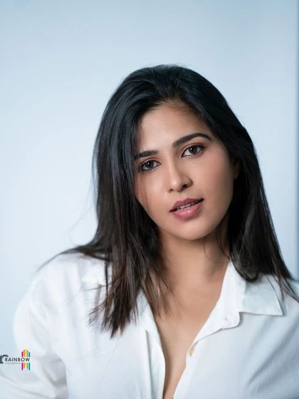 A relaxed yet confident pose in a classic white shirt. This type of shot is essential for showing natural versatility in a studio setting.