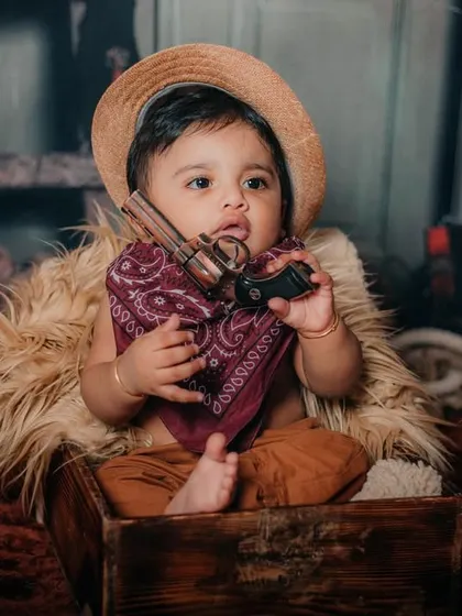 He's got his hat, his bandana, and his toy gun. This little cowboy is ready for anything.