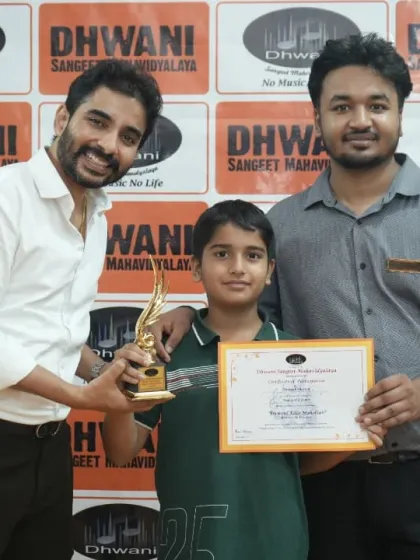 Two teachers present an award to a young student.