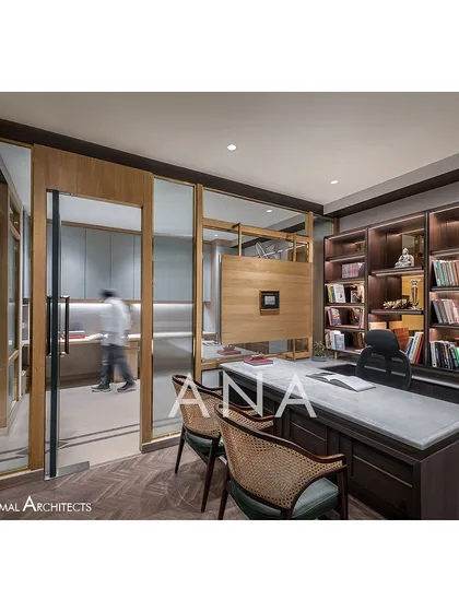 This angle of the MD cabin shows the glass partition with veneer cladding, which allows for visual connection to the rest of the office while maintaining privacy.