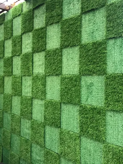 A close up of the two-tone checkerboard artificial grass wall. This custom pattern adds a unique, graphic element to the terrace design.