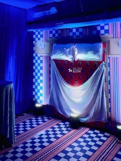 A bed setup with custom-printed bedding and dramatic blue uplighting, creating a cool and moody vibe.