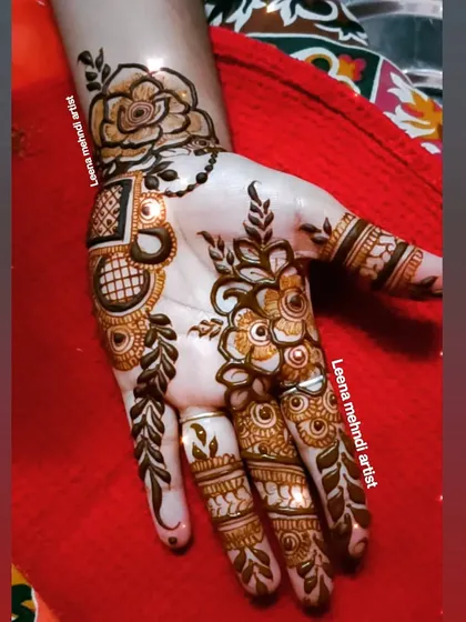 A stylish Arabic floral design for a guest. The pattern is open and flowing, with a prominent rose at the wrist and delicate vines extending to the fingers.