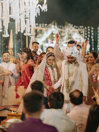 A wide shot of the pheras, capturing the entire scene with guests showering the couple with petals.