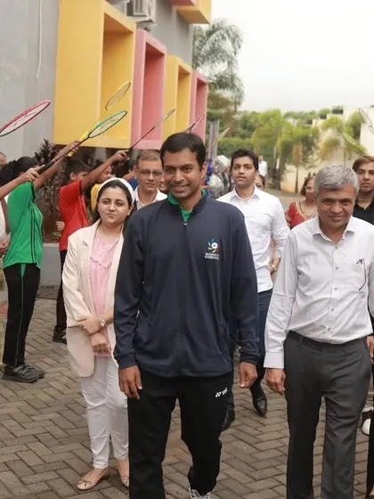 A grand welcome for Mr. Gopichand by the students at Crimson School, holding up rackets in an arch of honor.