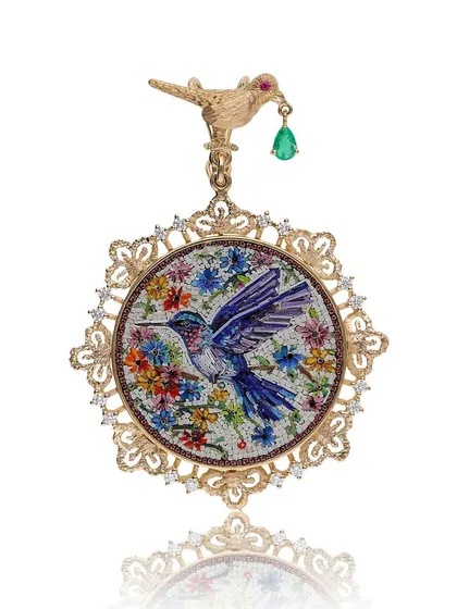 This pendant captures the fleeting moment of a hummingbird visiting a flower, crafted using the ancient art of micromosaic. Framed in textured 18k gold with diamond accents, a tiny bird holds a dangling Zambian emerald drop, symbolizing the sweetness of life.