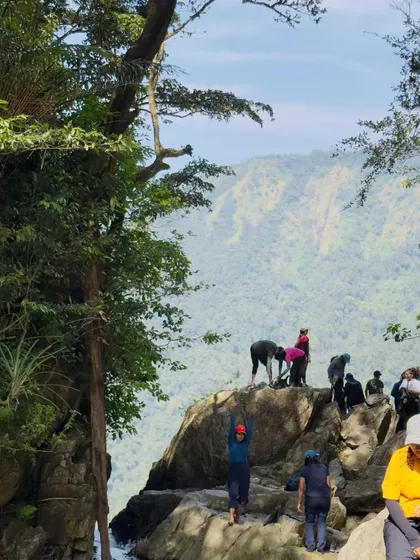 A group of trekkers at a viewpoint above a stream.