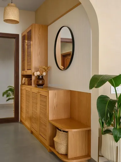 The foyer in 'Cover me in Sunshine' greets you with an arched entryway. The space combines style and function with an integrated shoe cabinet, mirror, and a comfortable seater bench.
