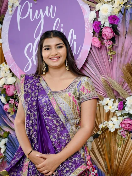 A close-up of the bride, her happiness shining through, framed by the floral and palm leaf decor.
