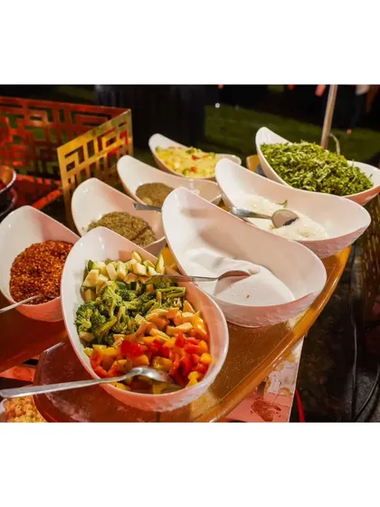 A colorful spread of fresh toppings for a build-your-own station, including chopped vegetables, herbs, and spices. Customization is key to my service.