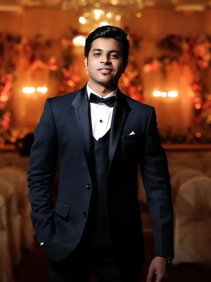 A classic portrait of the groom in his tuxedo. The warm, ambient lighting of the reception hall creates a sophisticated and timeless look.
