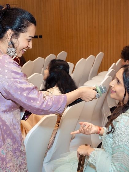 Moving through the audience to chat with guests at a baby shower. This personal interaction is key to my 'Host aur Dost' approach, making everyone feel like an old friend.