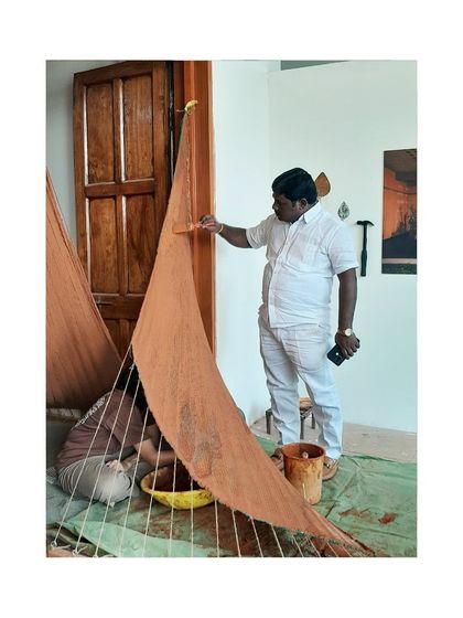 A visitor participates in plastering the mud installation, demonstrating our belief that building with natural materials is an accessible and communal activity.