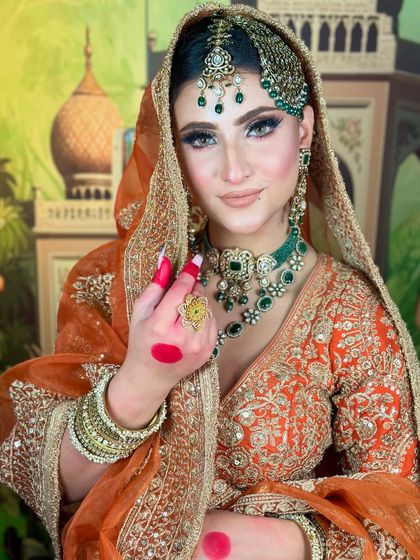 A direct portrait of the Pakistani bride. The makeup is kept elegant and glowing to balance the heavy jewelry and ornate outfit.