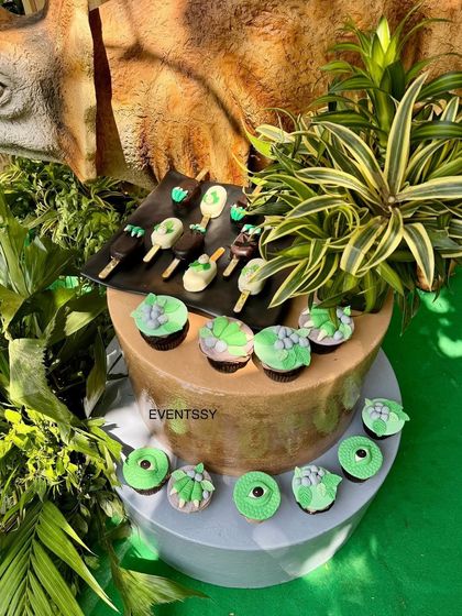 Themed desserts, including dinosaur eye cupcakes and fossil-themed cake pops, add to the prehistoric fun.