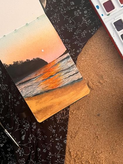 Living the artist's dream on a sandy canvas. This photo captures a magical moment of me painting a seascape with watercolors, live on the beach in Goa.