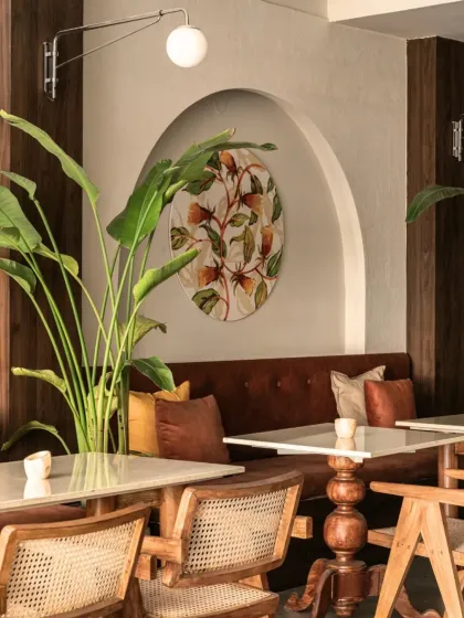A closer look at the details in our Balinese-inspired cafe. The combination of large tropical plants, warm wood finishes, and custom artwork creates a layered and refreshing ambiance that blurs the line between the indoors and nature.