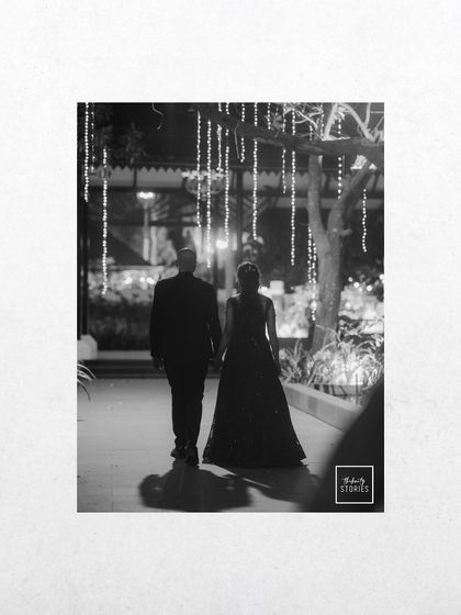 A romantic black and white photo of a couple walking away under twinkling lights. This shot feels like a scene from a classic movie, full of mood and elegance.