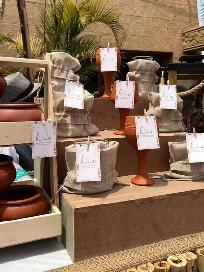 We use earthy and rustic props to enhance our boho theme, such as these terracotta pots and small burlap sacks, each adorned with a personalized event tag.