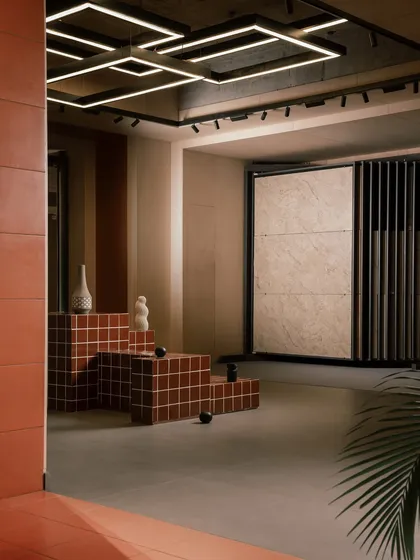 This area in the Trove showroom features tiled, multi-level seating that doubles as a product display. The geometric lighting on the ceiling and the organized pull-out racks create a modern and user-friendly environment for exploring materials.