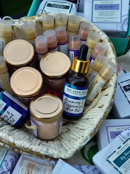 A heart-shaped basket filled with my products, including body butters, hair oils, and lip balms, at a Christmas market.
