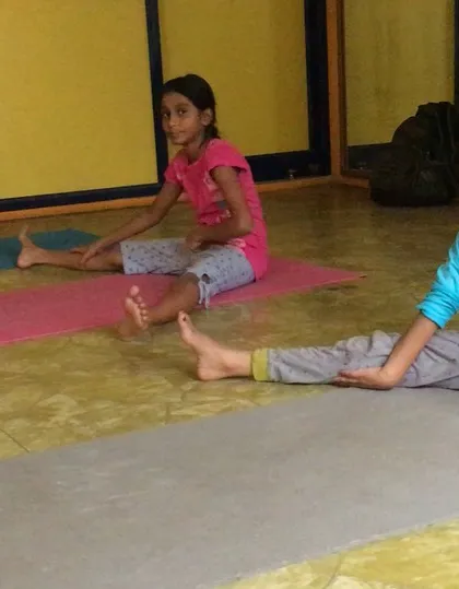 Another shot of the kids' class, where they are learning foundational stretches. Introducing yoga early helps develop body awareness and flexibility that lasts a lifetime.