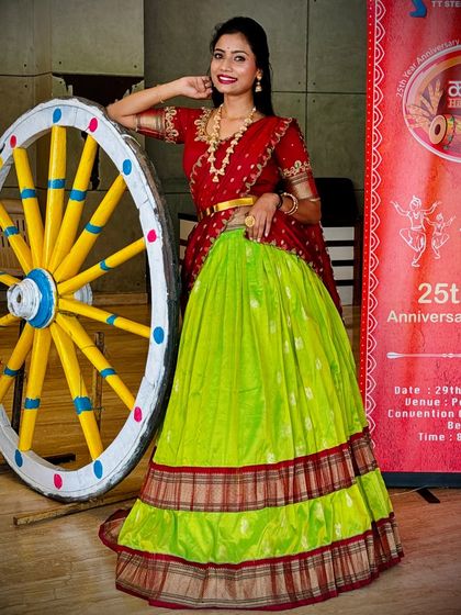 Here is the same popular half saree design, worn by singer Divya Ramachandra for a "Halli Habba" themed event. It shows how versatile this traditional outfit is, perfect for both personal functions and stage performances.