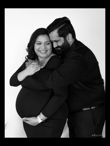 Wrapped in his arms, safe and loved. A timeless black and white image that shows the beautiful connection between a couple on their pregnancy journey.