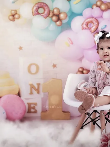 This first birthday shoot features a dreamy pastel donut and ice cream theme. The soft lighting and sweet props create a whimsical atmosphere for your little girl's big day.