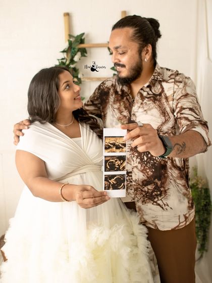 A beautiful way to share the first glimpse of your baby. The couple holds up the sonogram pictures, their faces full of love and anticipation.