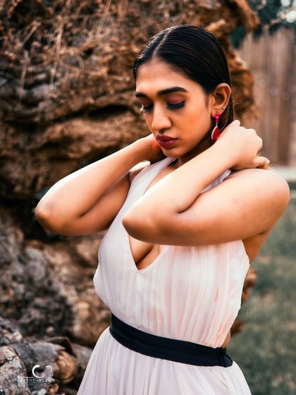 A soft and introspective moment. Her pose is graceful, and the natural setting adds a sense of peace and tranquility.