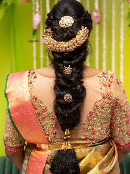 A look at the intricate traditional hairstyle created for Sukrutha's baby shower, featuring a beautiful braid adorned with gold accessories.