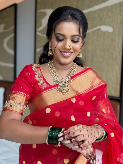 The bride adjusting her bangles, a classic bridal pose. Her makeup is long-lasting, designed to withstand all the moments of a busy wedding day.
